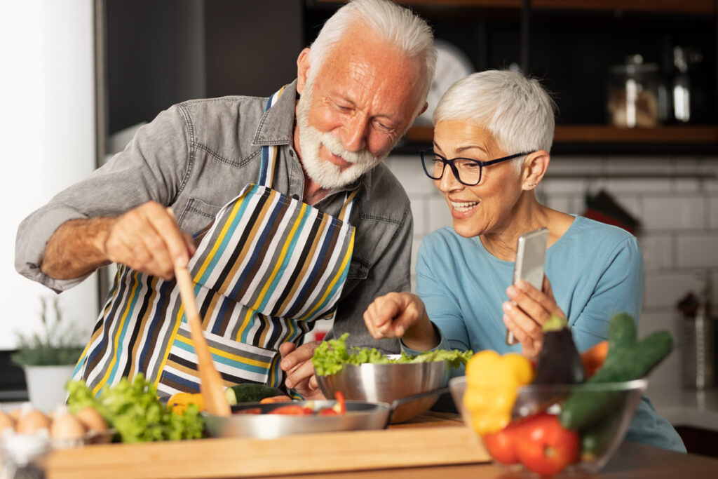 Healthy older couple preparing whole food plant based meal.