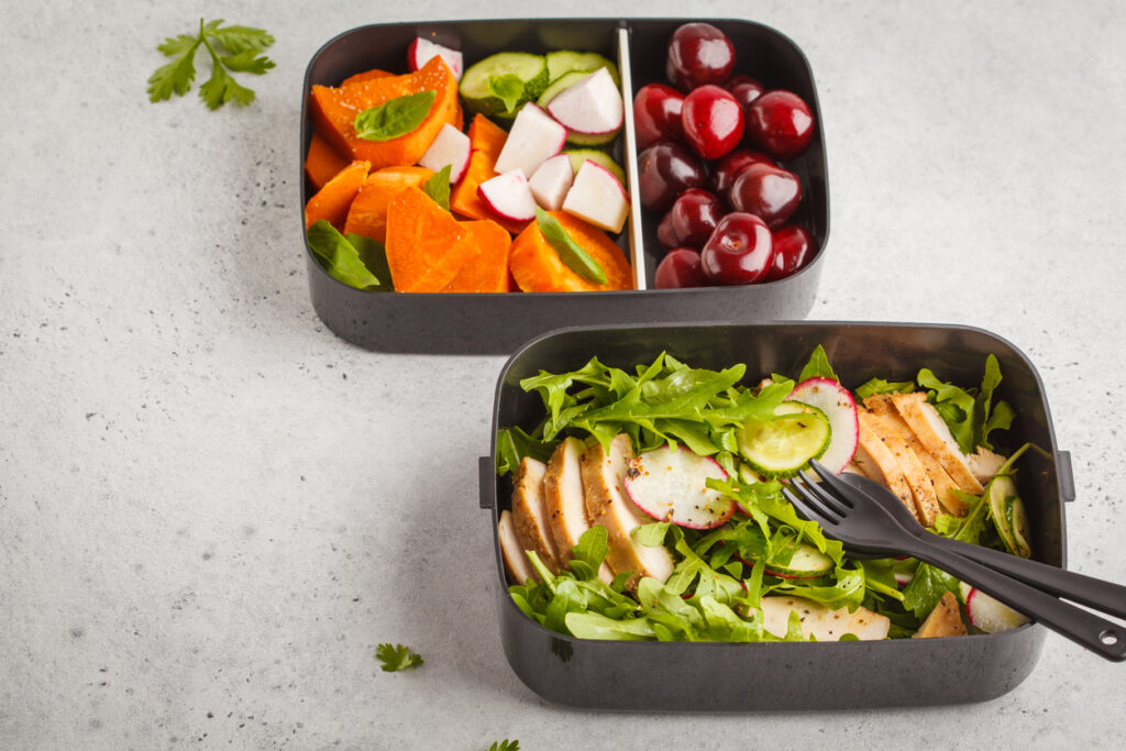 Meal prep containers filled with a variety of whole foods.